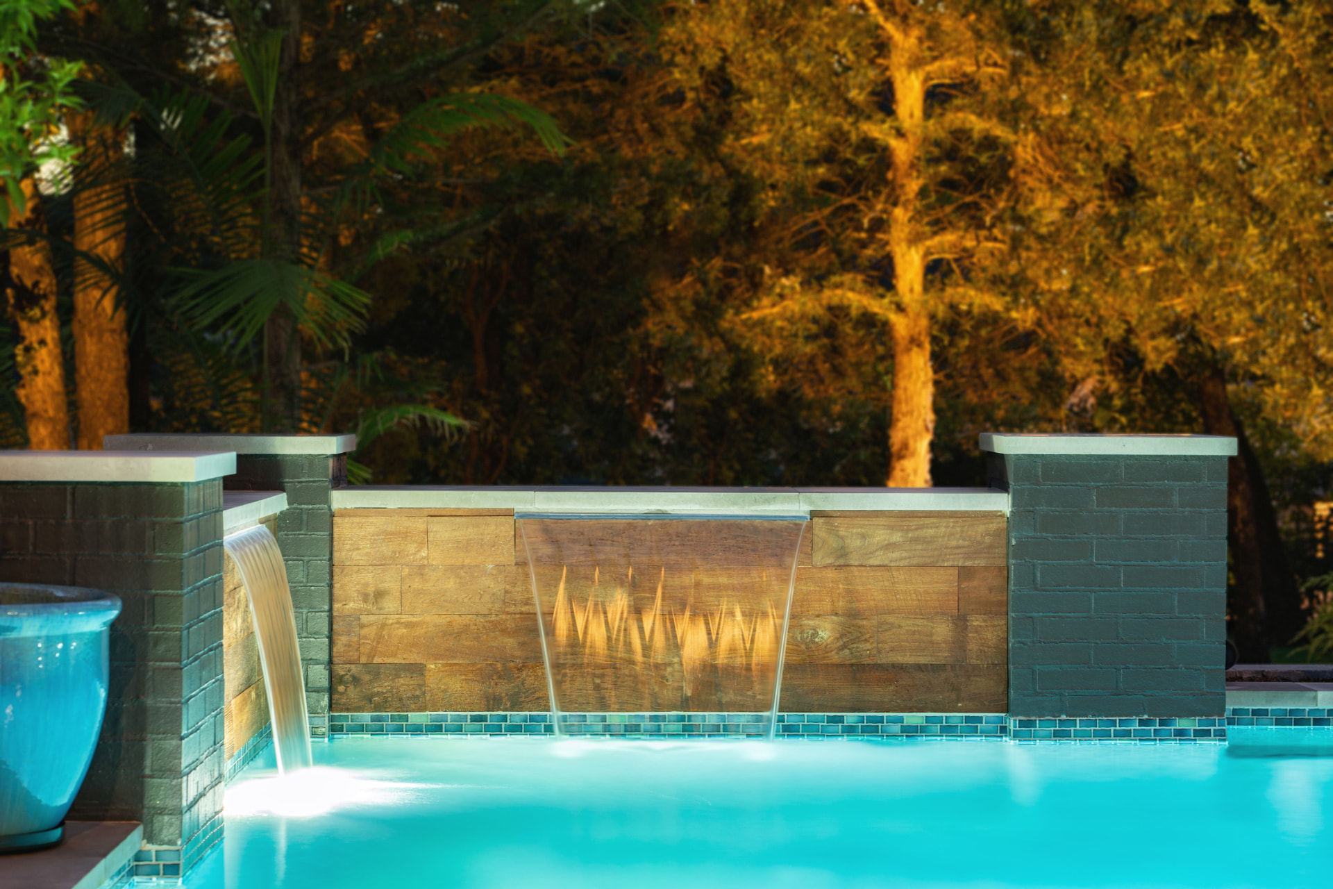 Sheer descent waterfalls over timber veneer and painted brick columns