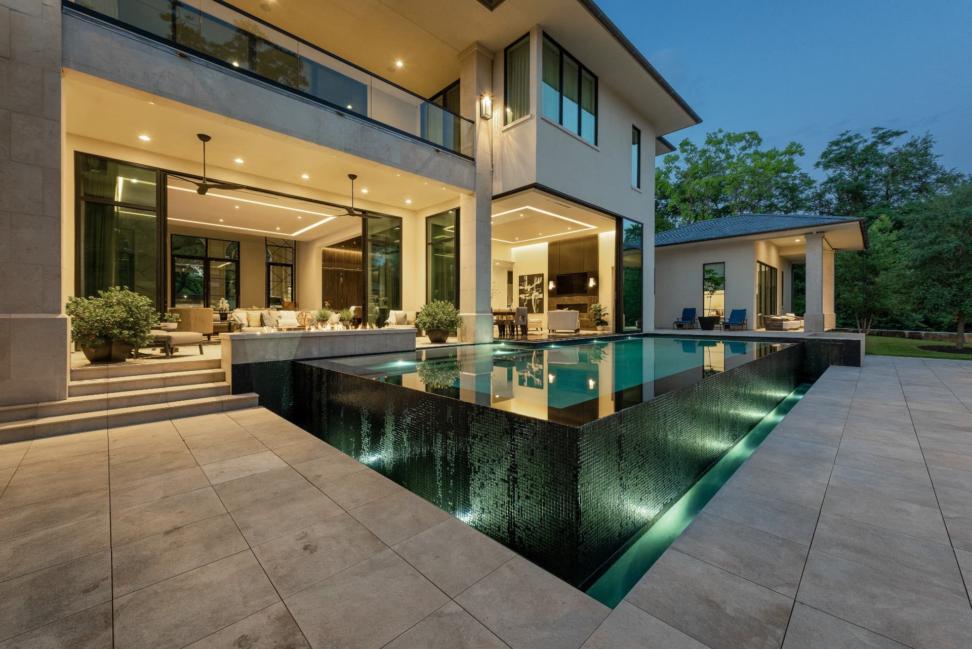 Dark tile vanishing edge wall and porcelain paver deck
