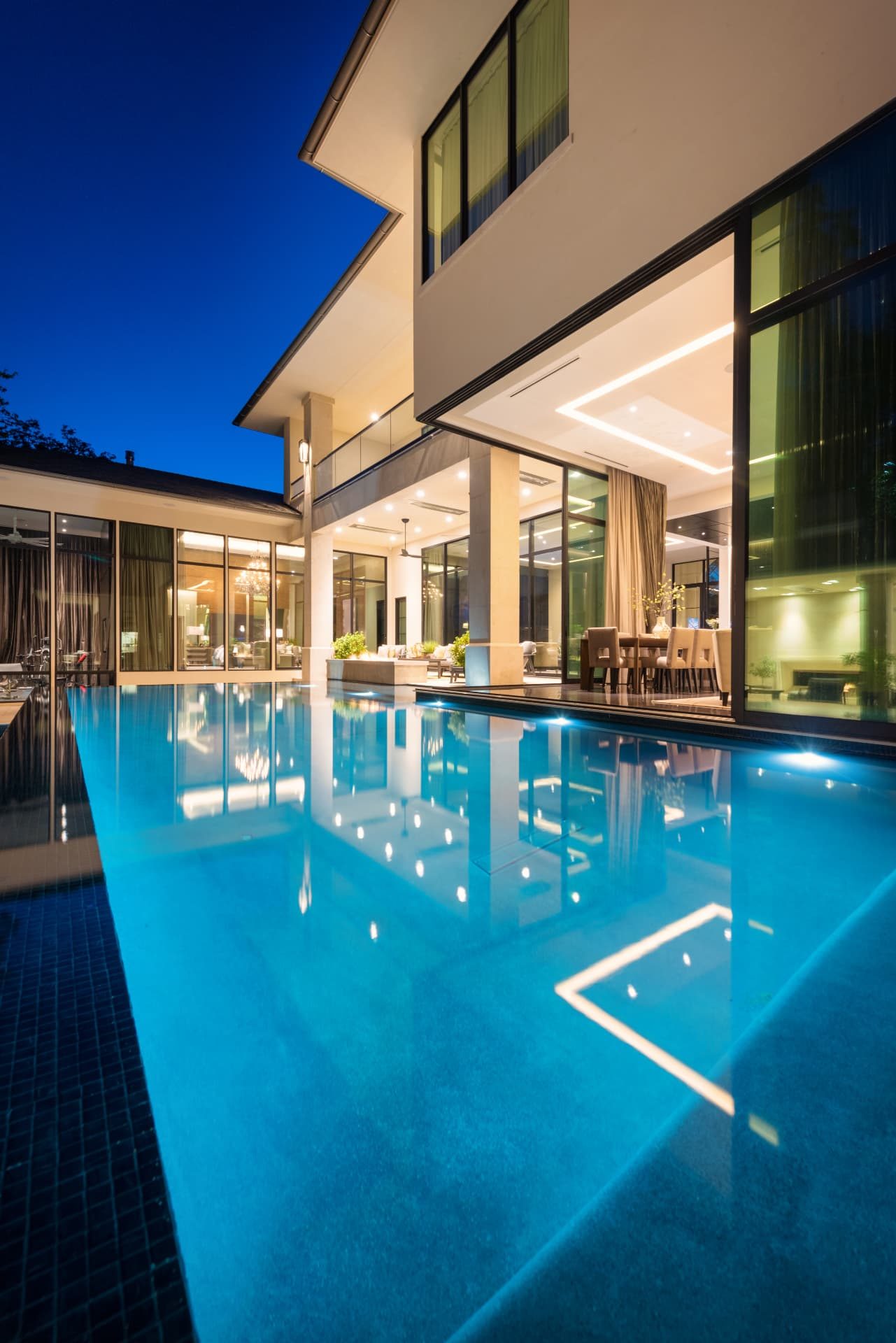 Vertical view of the perimeter-overflow pool alongside the illuminated home