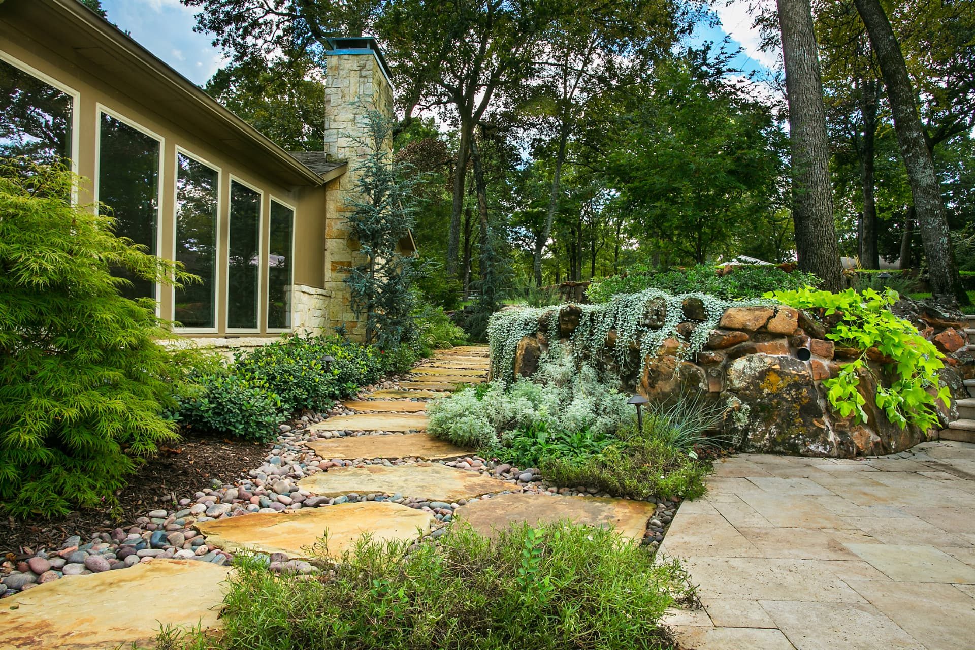 Flagstone path and layered plantings alongside the home