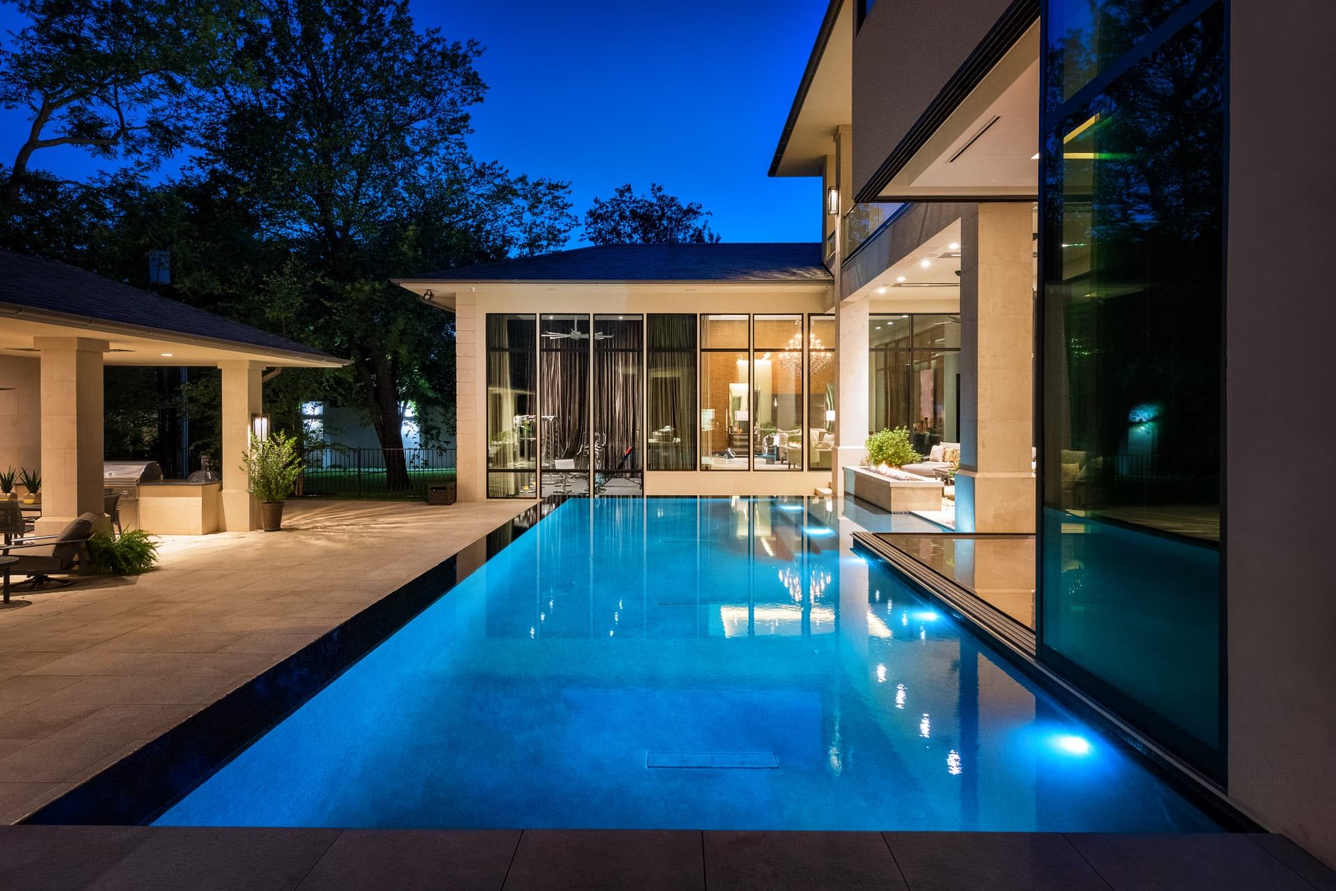 Structured Straightline pool at dusk with water reaching the edge of the home