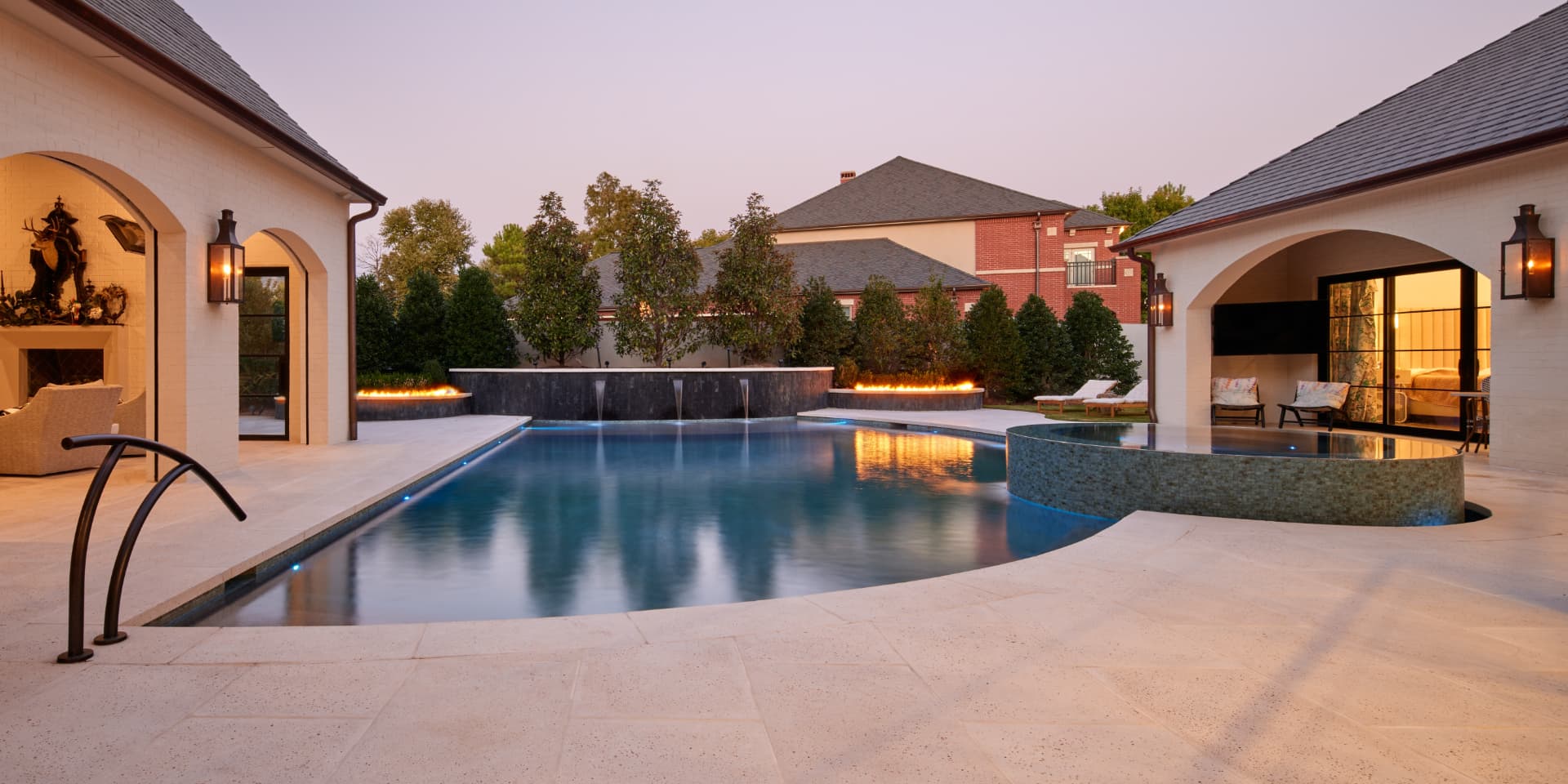 Curved pool with fire features and raised spa