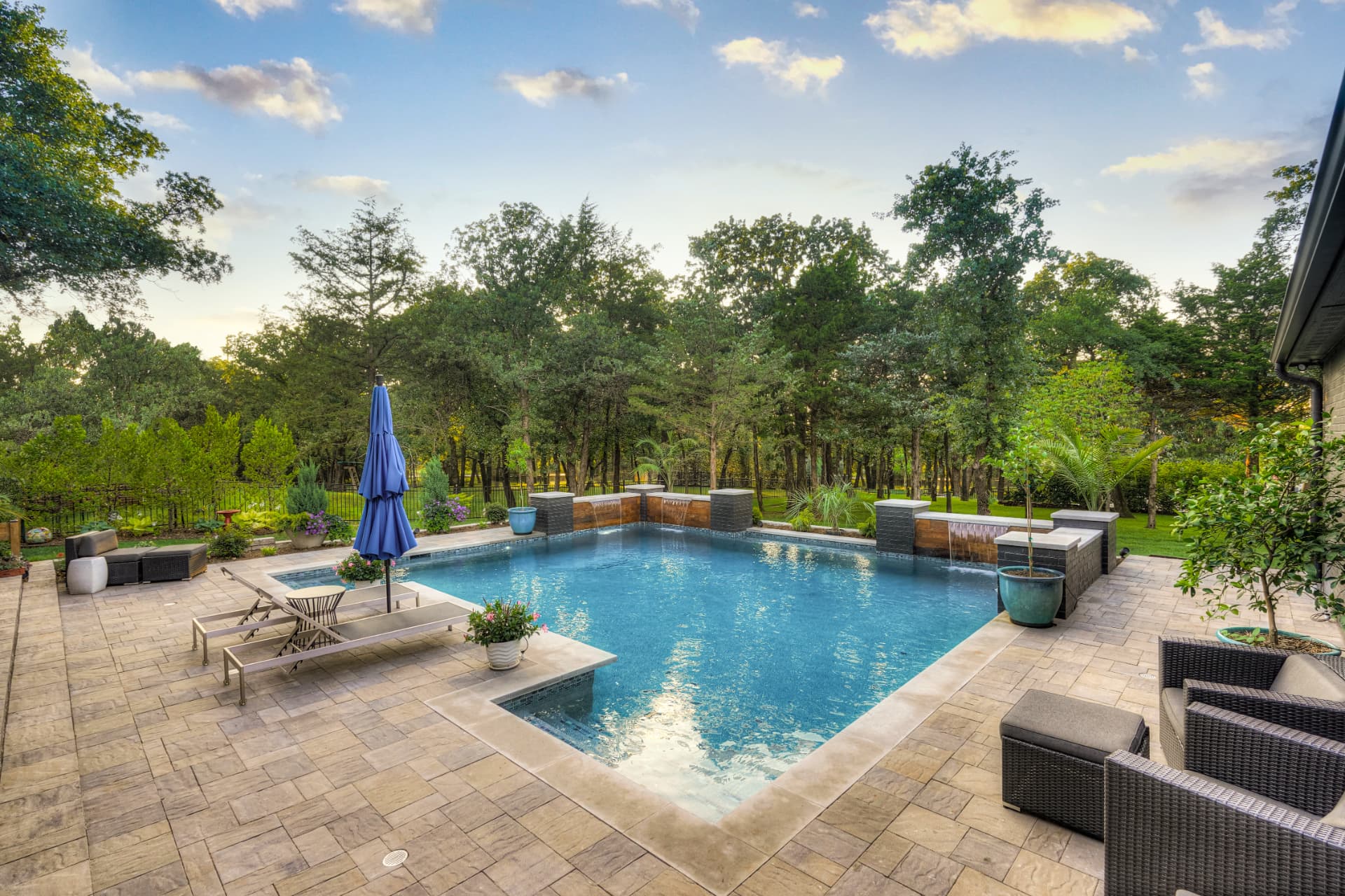 Wide view of the pool at dusk with cedar and brick feature walls