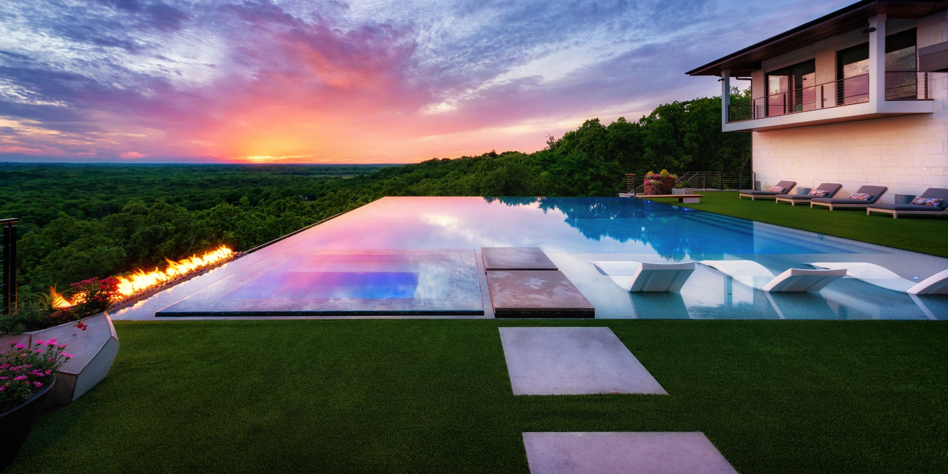 Infinity edge pool with fire line at sunset